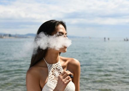 2026 年戶外海邊，用戶體驗加熱不燃燒（HNB）技術所產生的低溫精準萃取蒸汽，展現極致感官美學