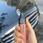 手持 RELX 電子煙白桃烏龍口味的實拍展示與生活質感紀錄