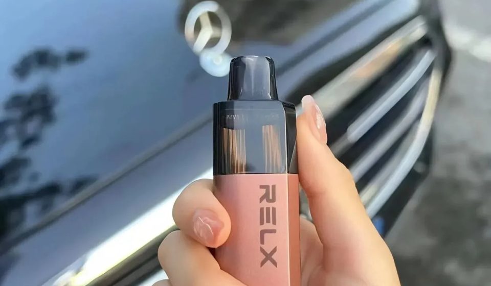 手持 RELX 電子煙白桃烏龍口味的實拍展示與生活質感紀錄